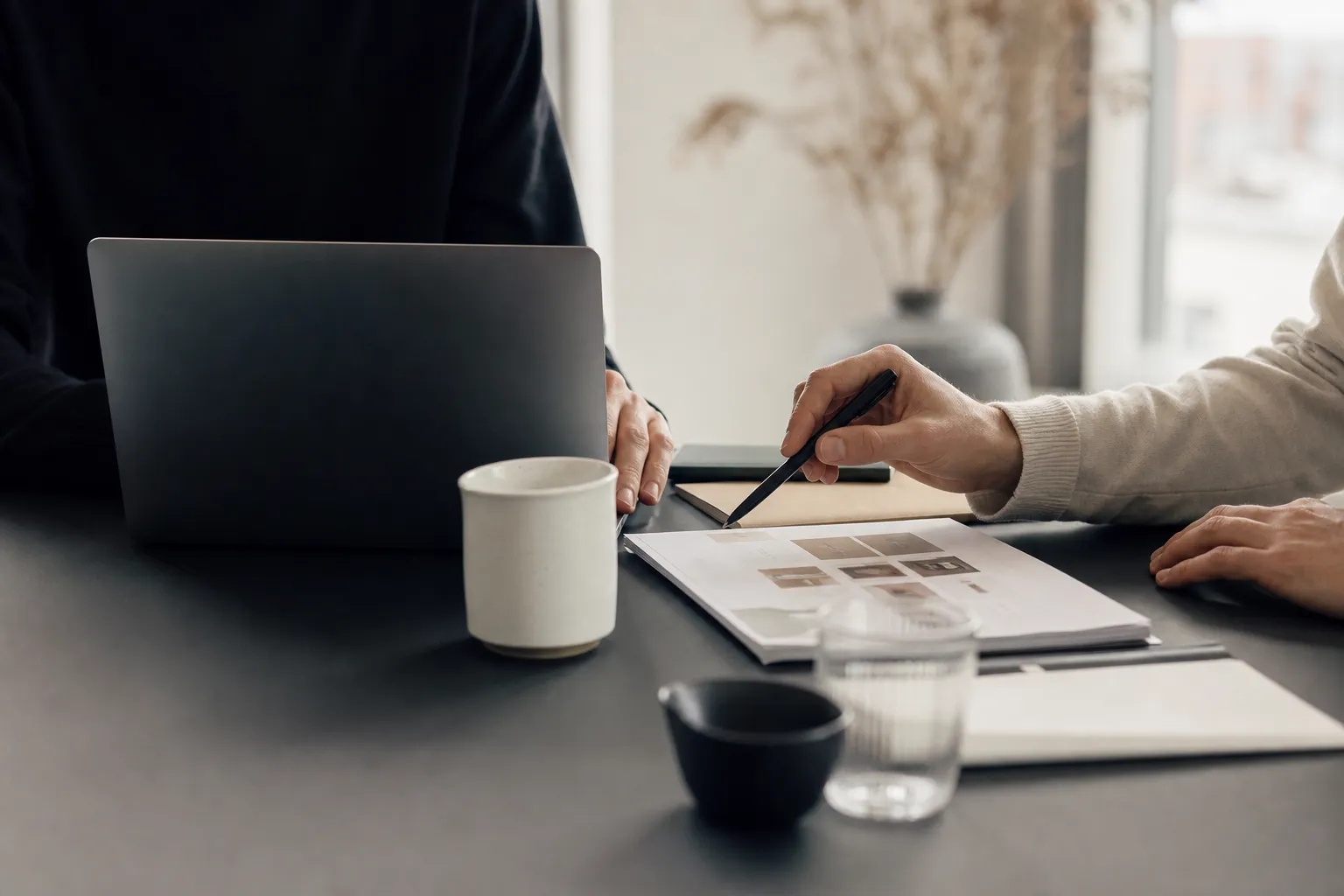 To personer samarbejder om wireframes for en hjemmeside ved skrivebord med laptop