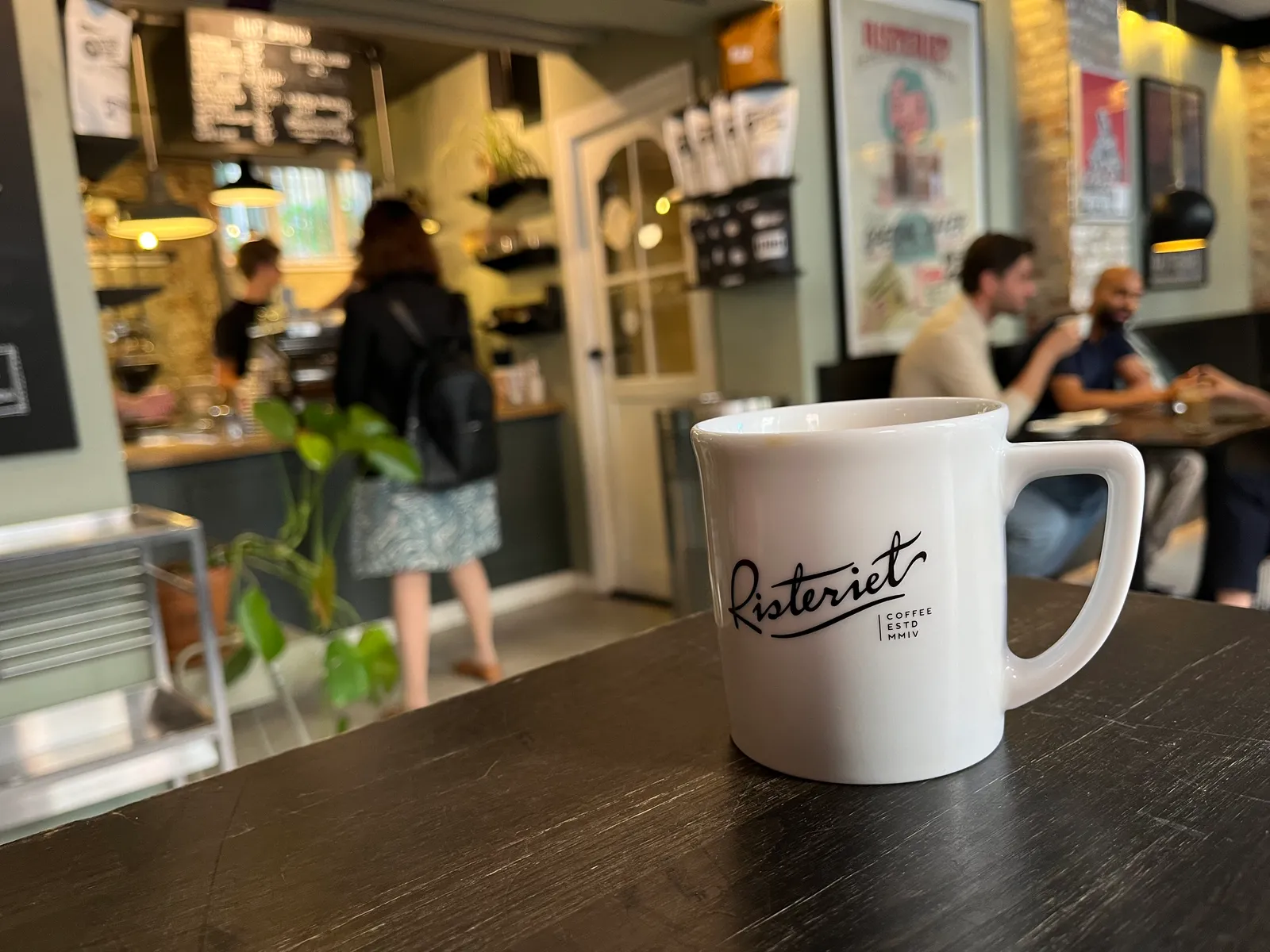Hvid Risteriet-kaffekop på bord i den hyggelige kaffebar.