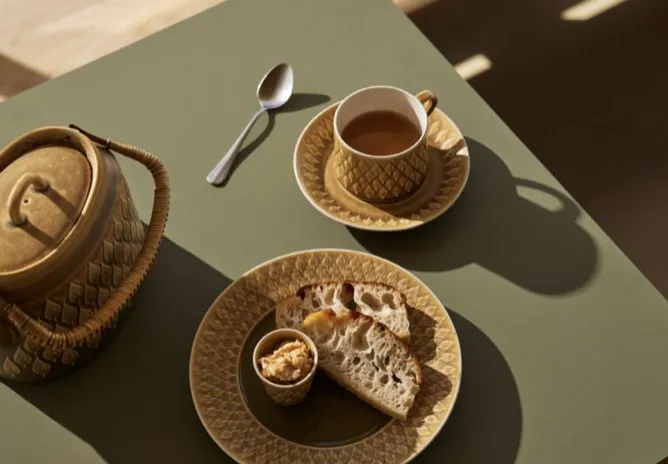 Varm kaffe i kop med toast og smør på plade