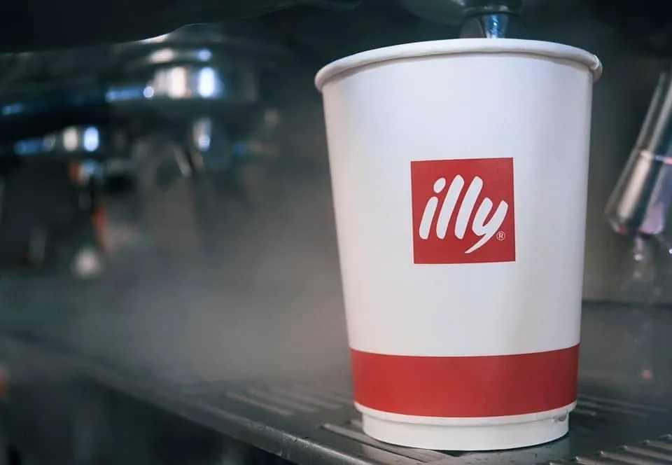 En hvid og rød illy kaffekop på en café disk